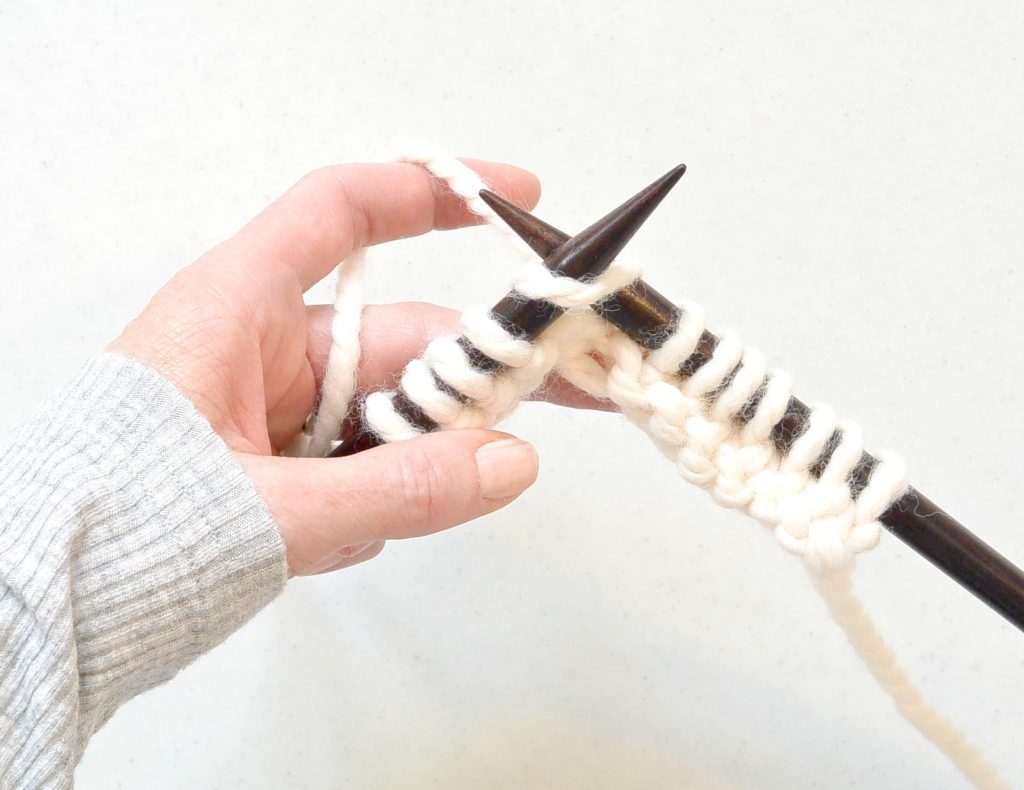 woman showing how to knit and how it's similar to crochet
