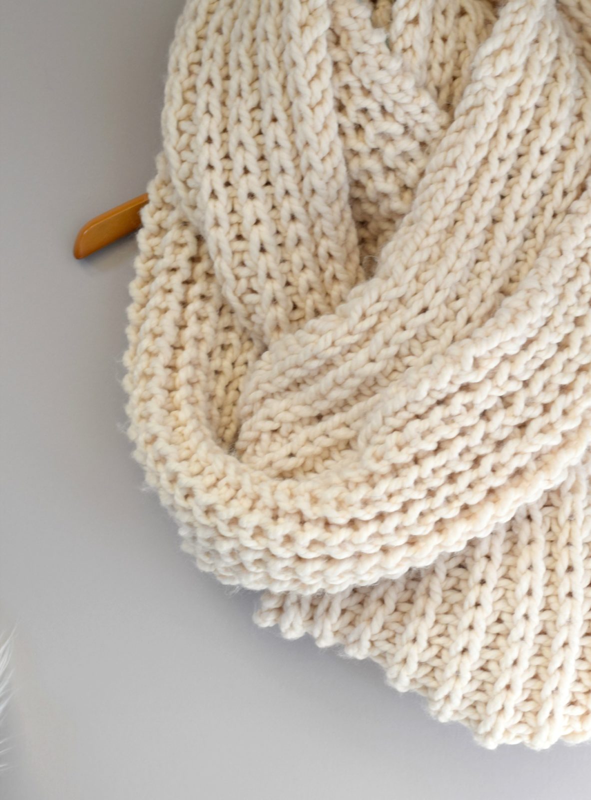 A Knitted Scarf With A Thick Thread On Thick Beige Knitting