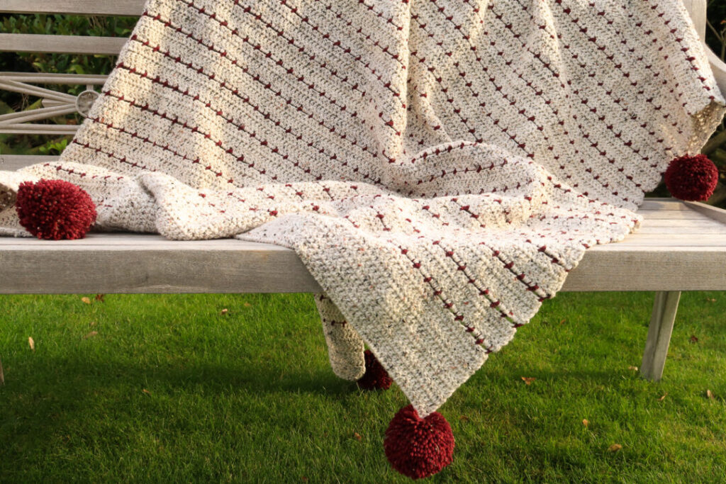 Chunky Poms on A Crochet Blanket